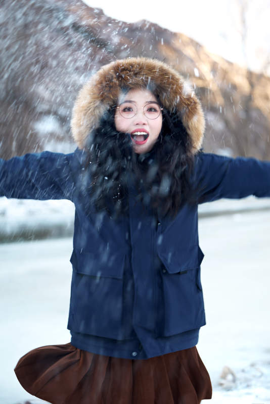在野外雪地欣赏雪景游玩拍照的亚洲女性图片
