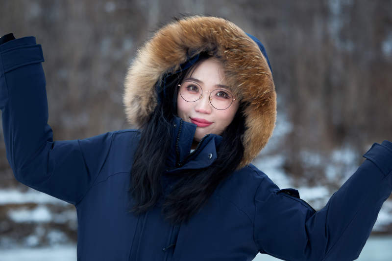 在野外雪地欣赏雪景游玩拍照的亚洲女性图片