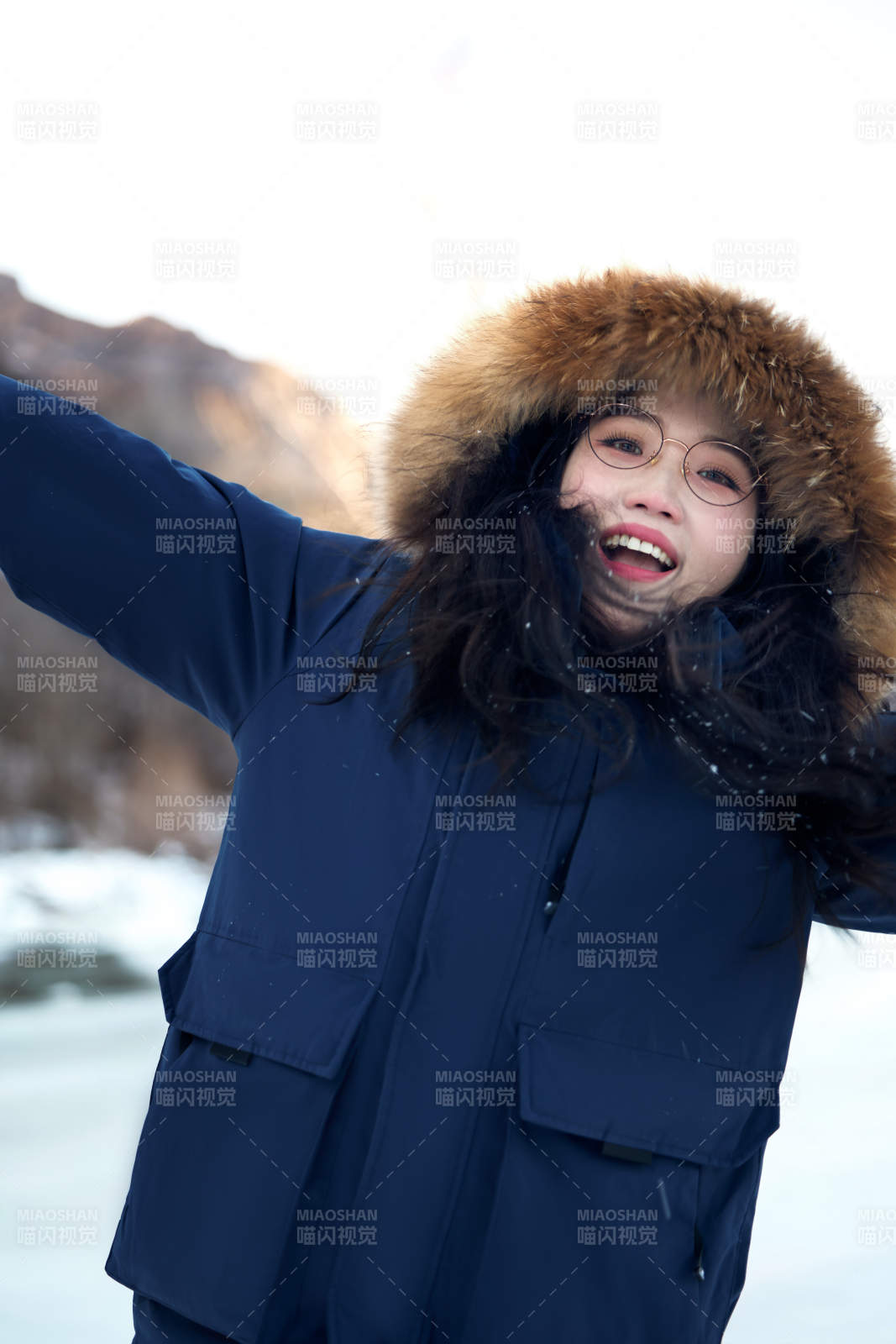 在野外雪地欣赏雪景游玩拍照的亚洲女性图片