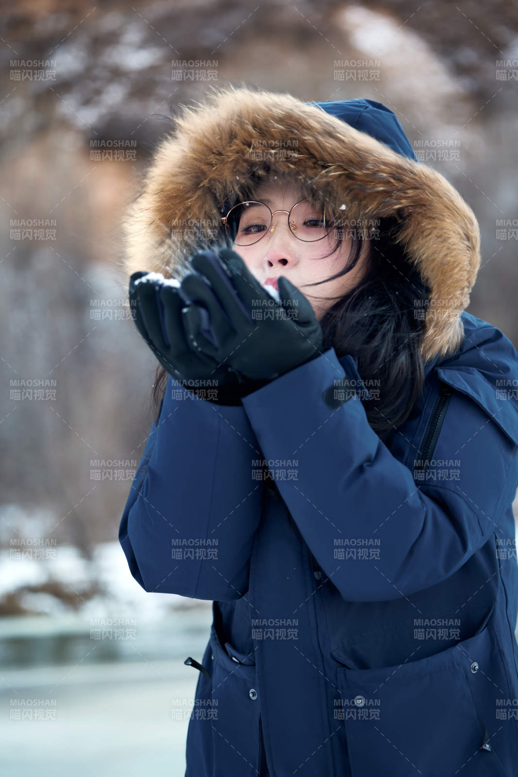 在野外雪地欣赏雪景游玩拍照的亚洲女性图片