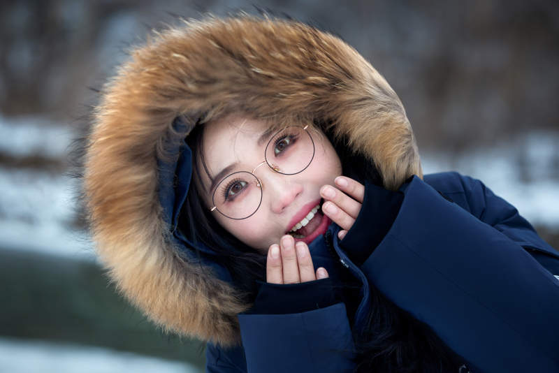 在野外雪地欣赏雪景游玩拍照的亚洲女性图片