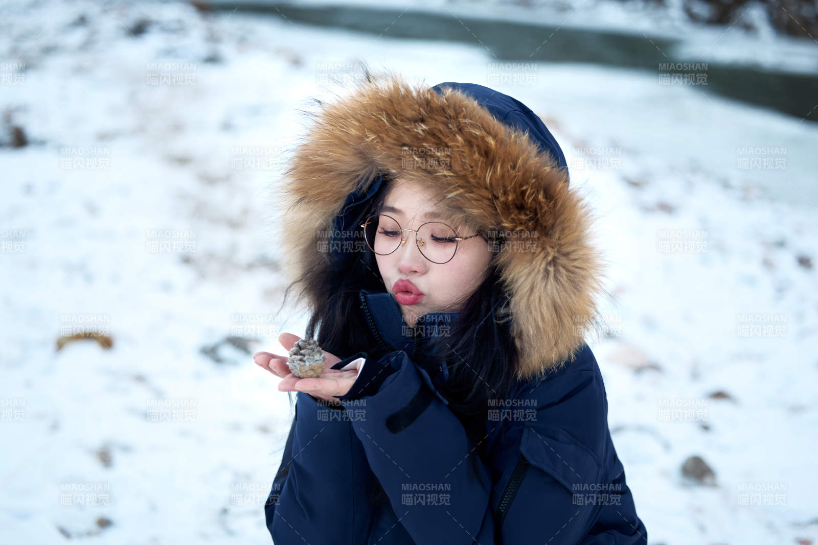 在野外雪地欣赏雪景游玩拍照的亚洲女性图片