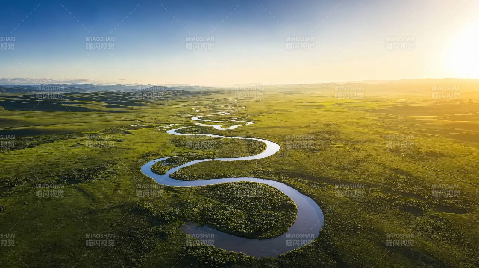 蜿蜒河流绿野间图片