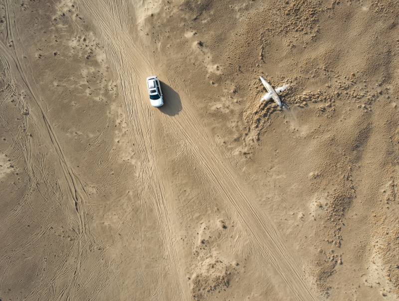 沙漠中的车与飞机图片