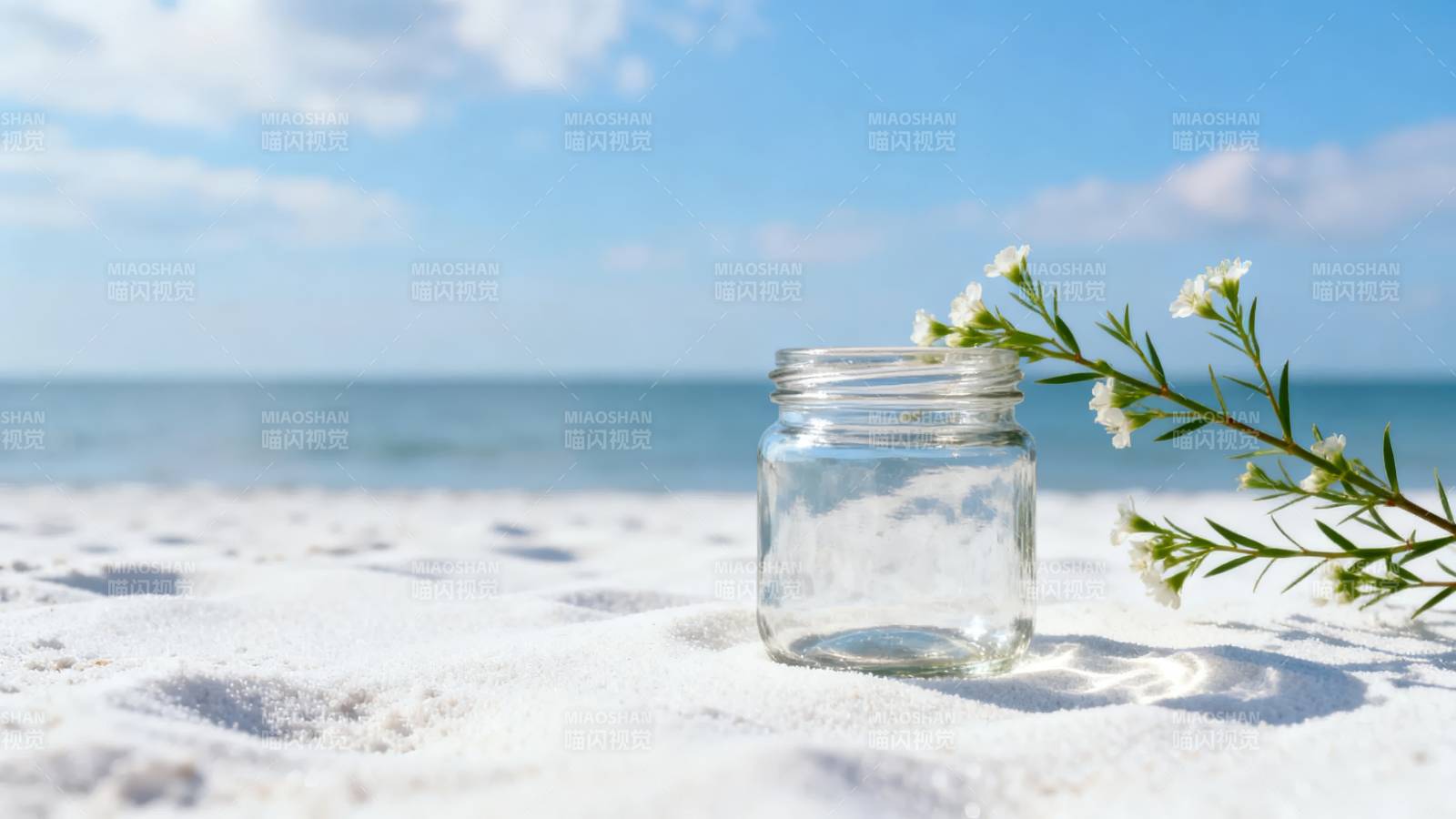 沙滩上的玻璃瓶与花图片