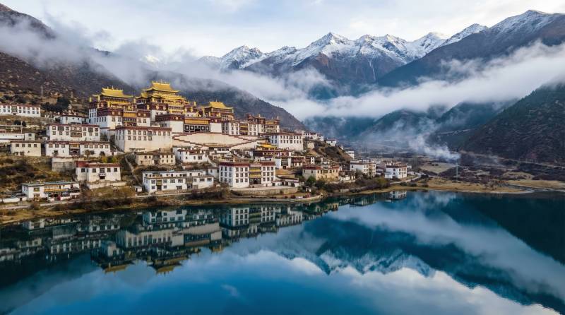 雪山映湖畔古寺图片