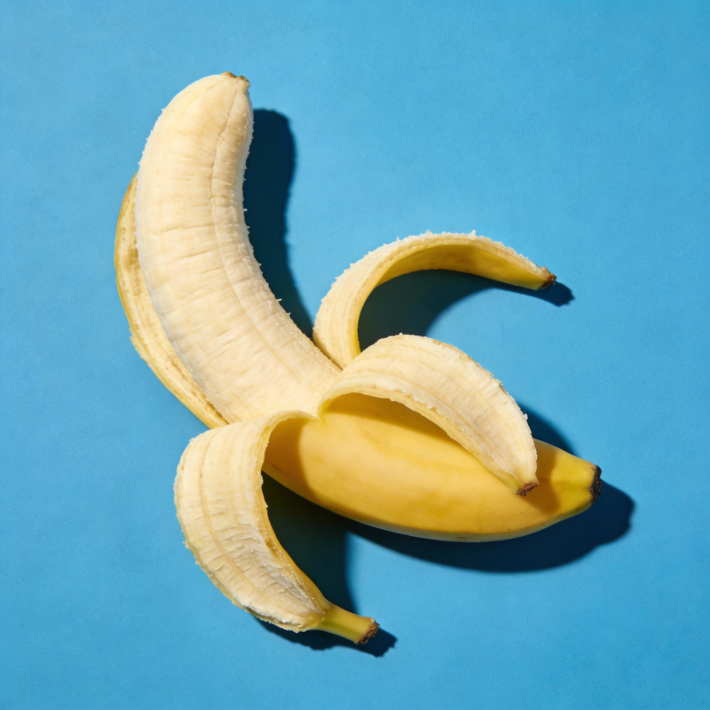 香蕉剥皮 蓝色背景图片