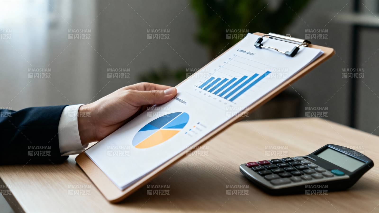 办公桌上的数据图表与计算器图片