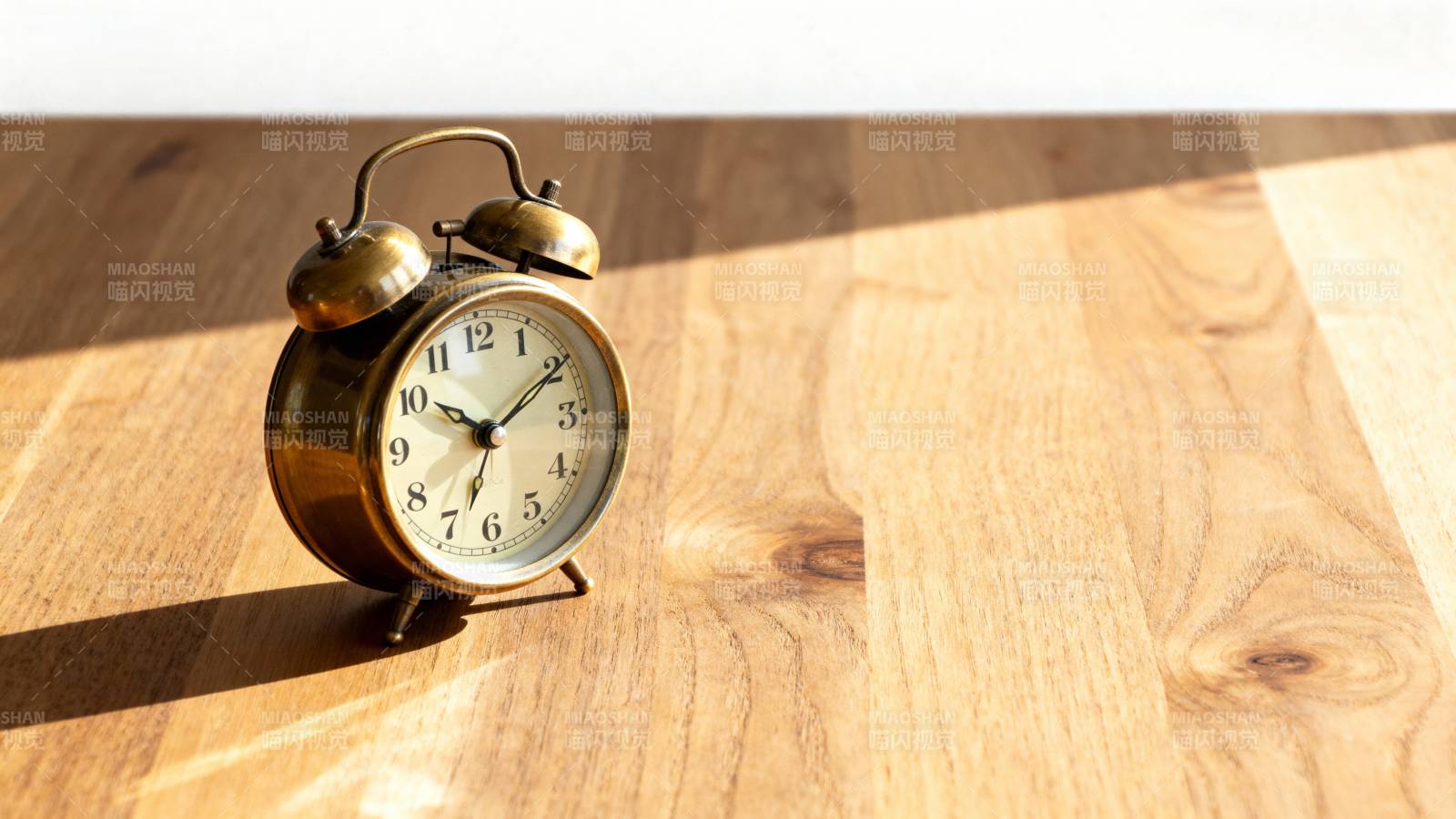 复古闹钟静置于木桌图片