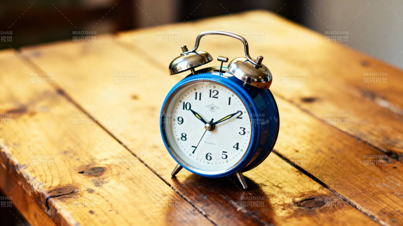 蓝色闹钟静置木桌图片