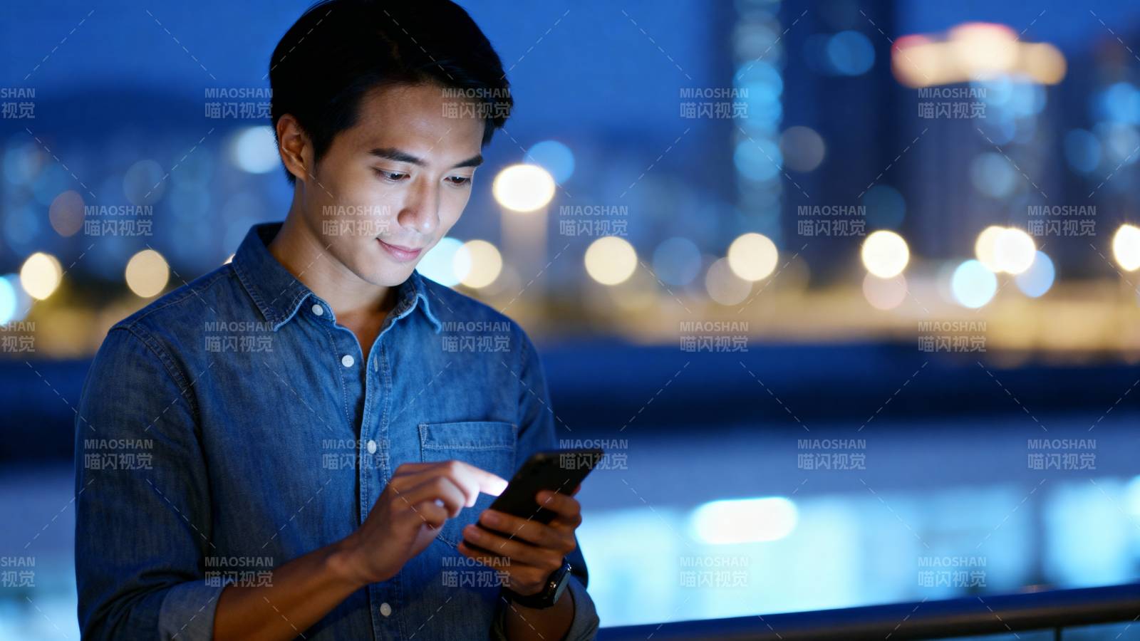 夜景中专注看手机图片