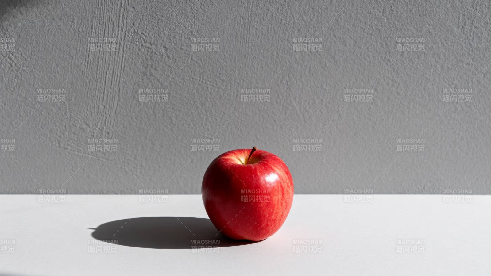 红苹果静置于白桌图片