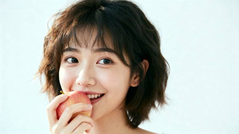 少女咬苹果微笑图片