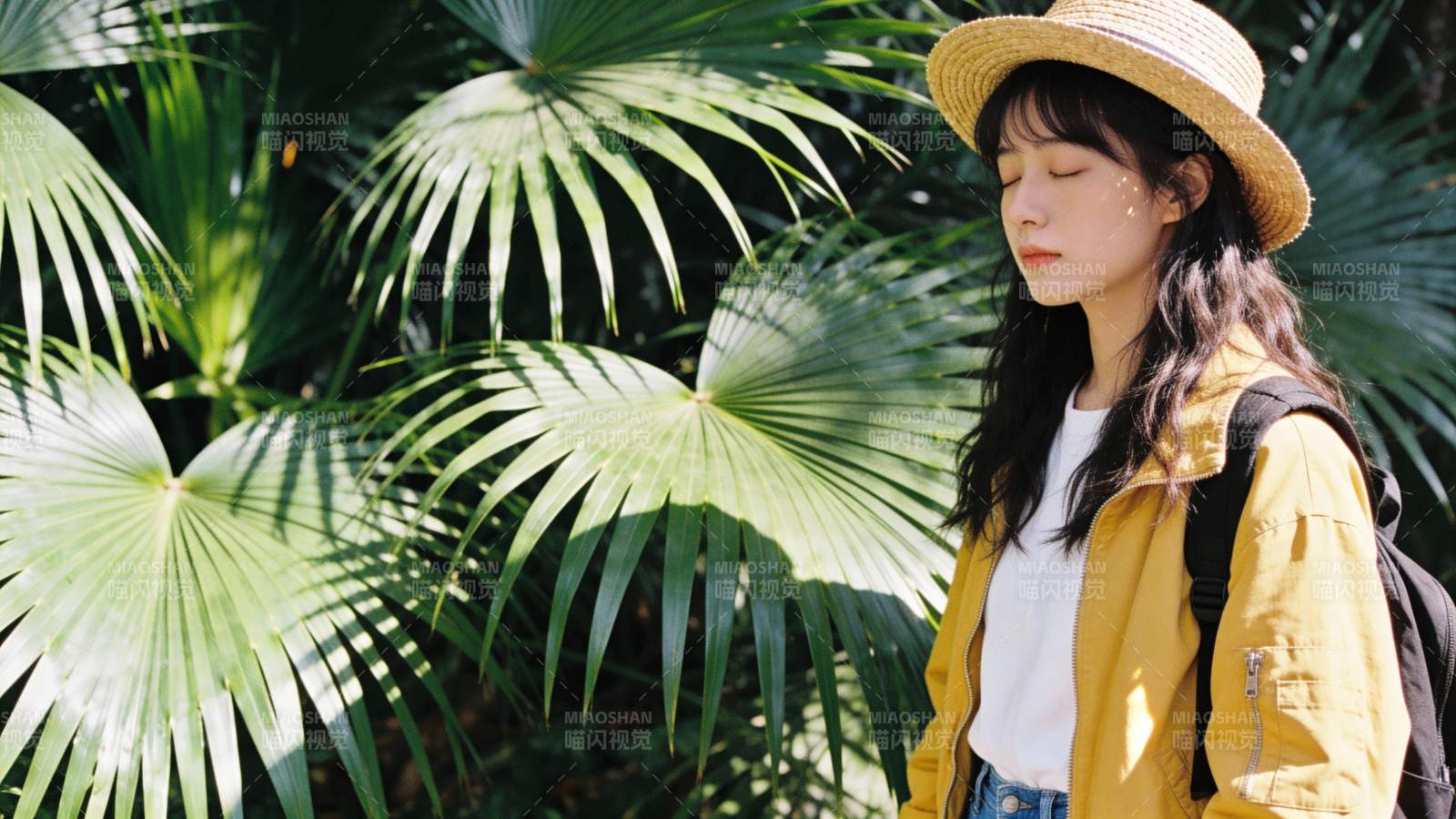 戴草帽女子在绿植前闭目养神图片