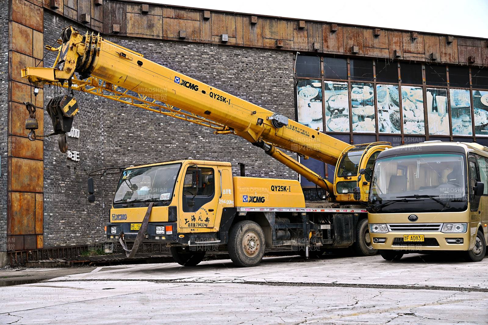 黄色吊车停靠在施工建筑旁图片