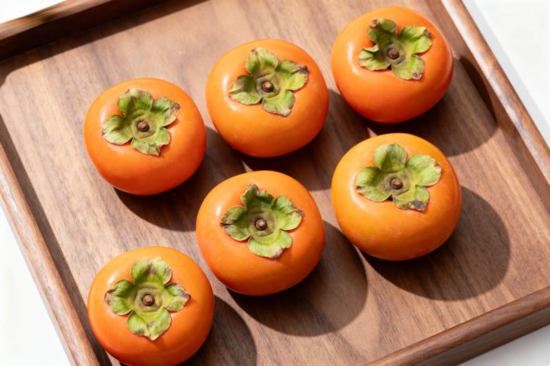 木盘上的六个柿子图片