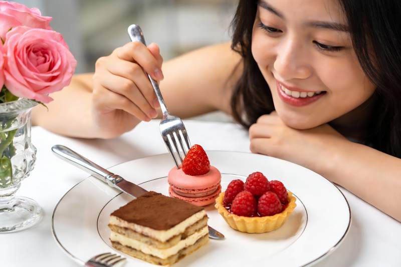 女子享用精致甜点的温馨瞬间图片