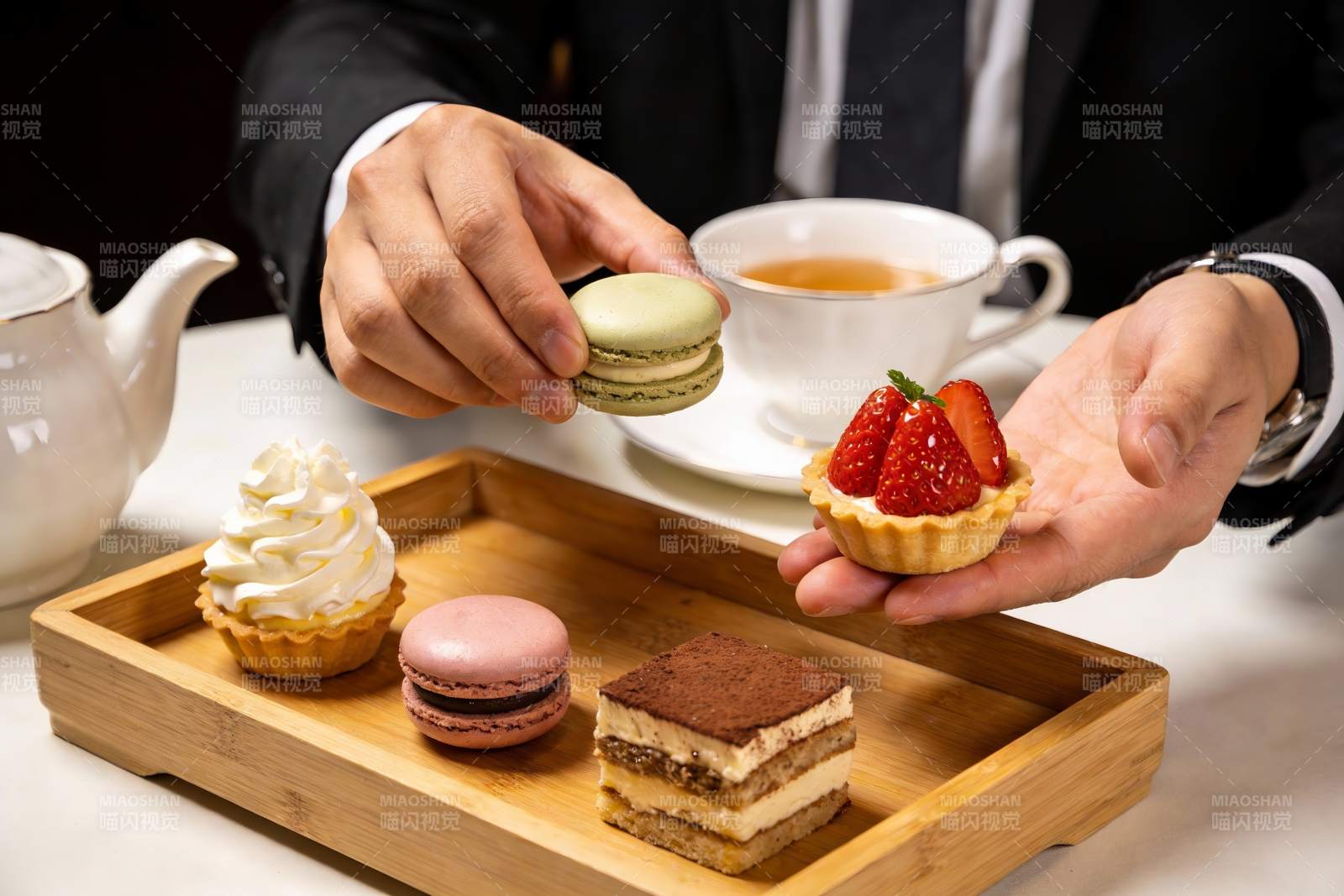 西装人士手持甜点与茶图片