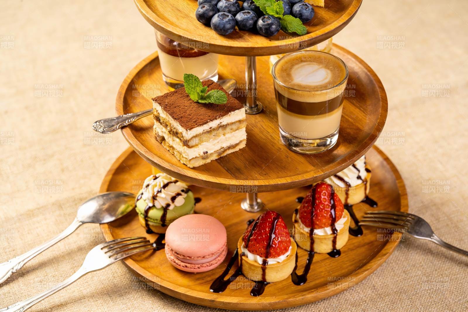 三层木质甜品架摆满精致糕点图片