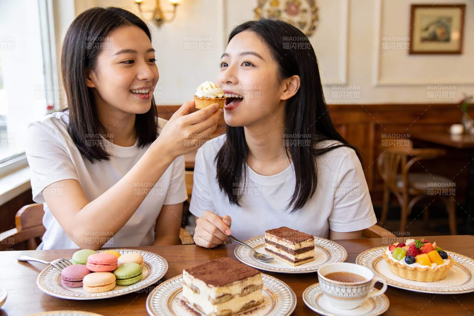 两位女子在咖啡馆分享甜点图片