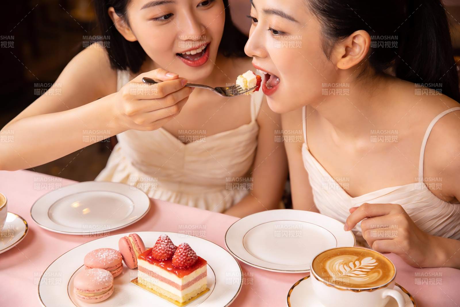 两位女士共享甜点的温馨瞬间图片