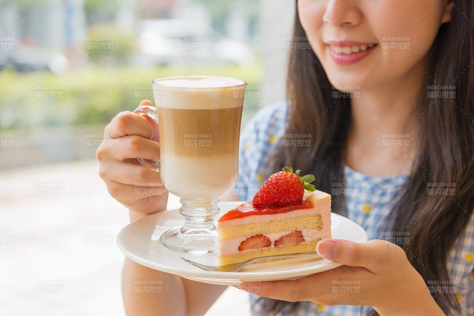 女子手持咖啡与草莓蛋糕图片