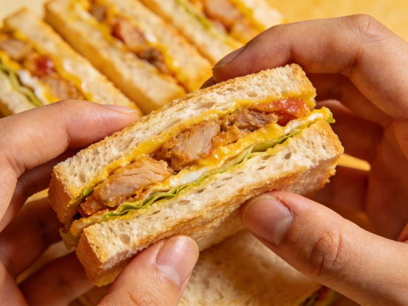 手握美味三明治特写图片