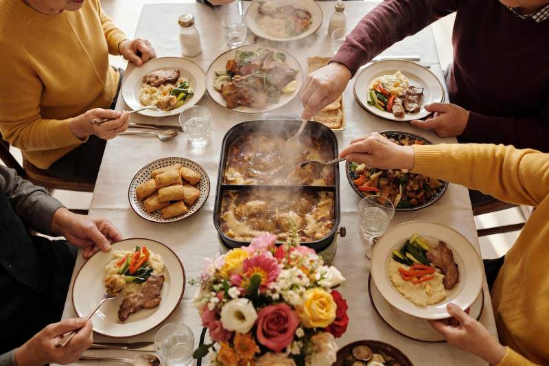 多人围桌共享美食聚餐场景图片