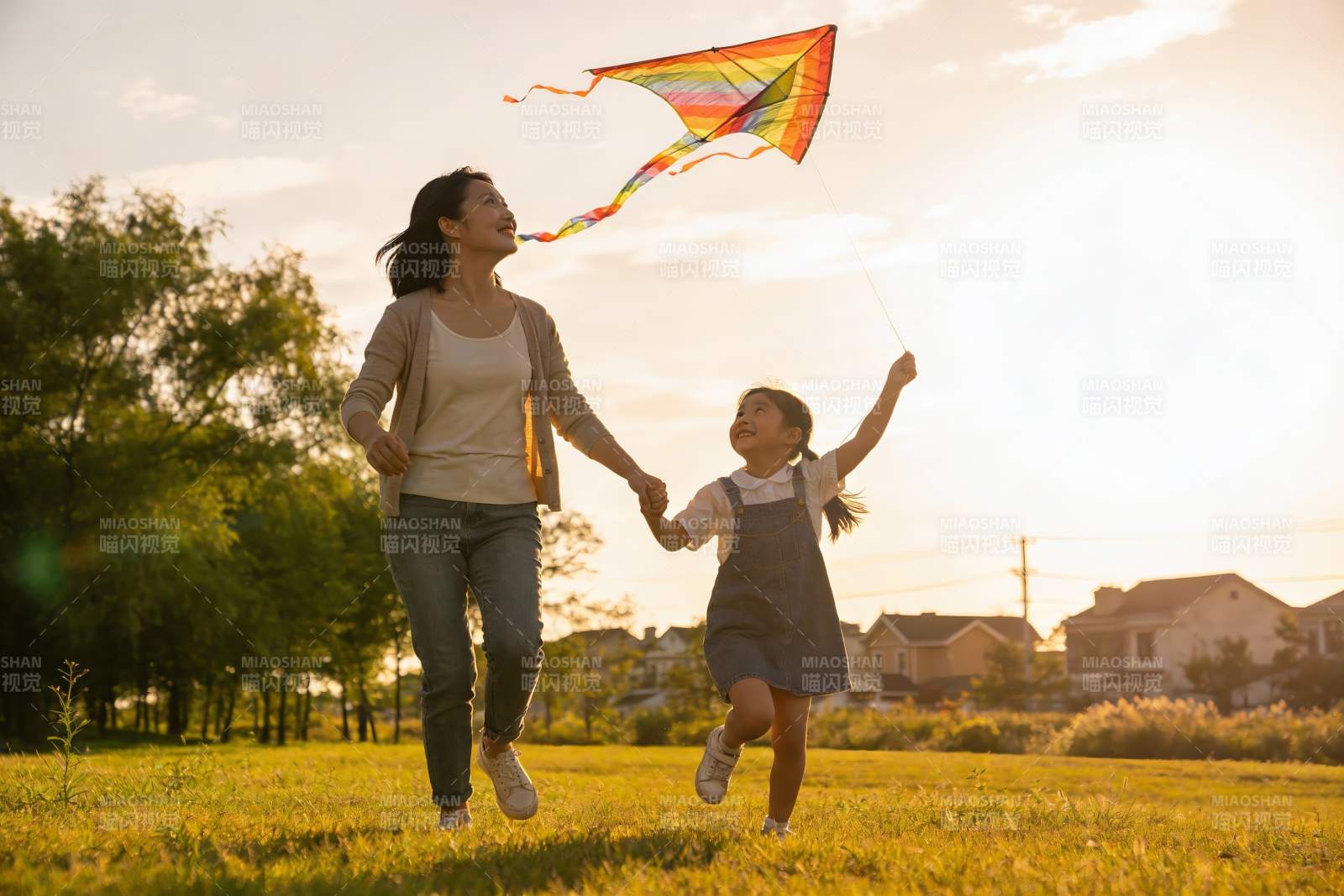 母女草地上放风筝欢乐奔跑图片