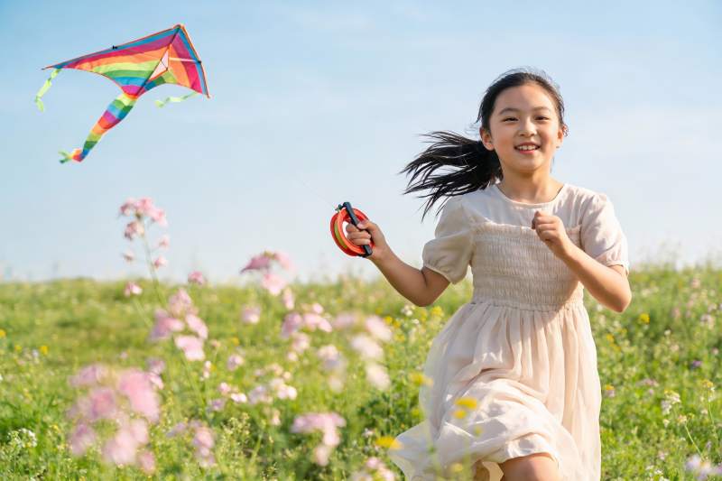 小女孩草地上放风筝图片