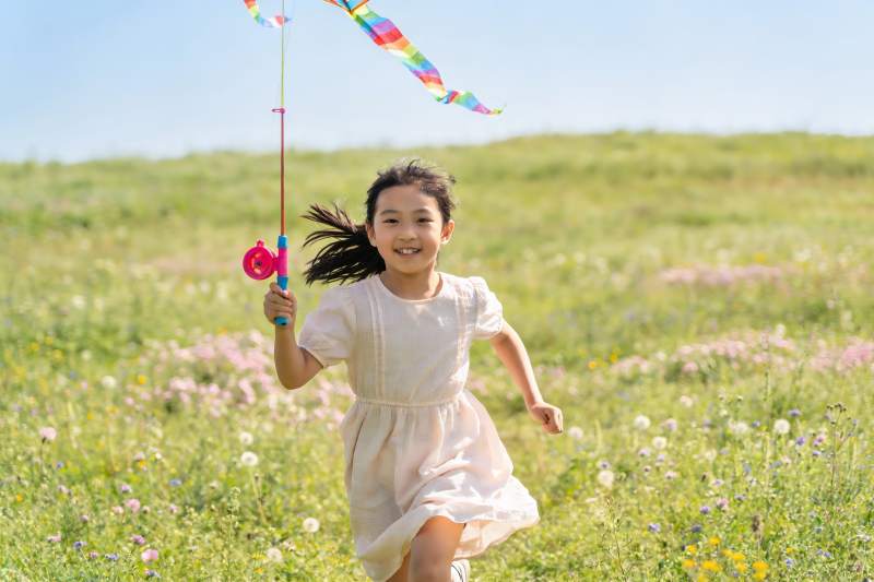 小女孩草地上放风筝图片