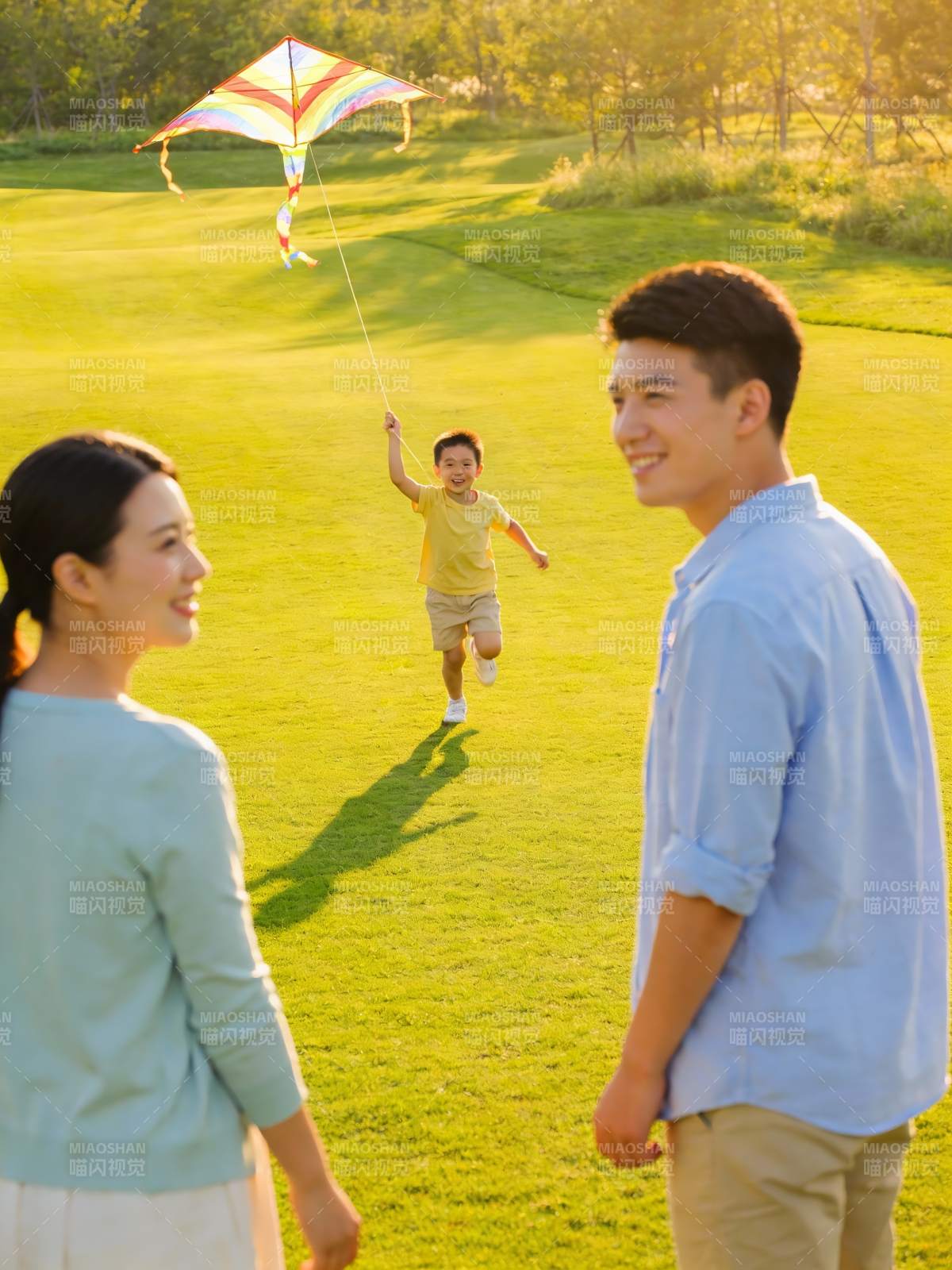 三口之家草地上放风筝图片