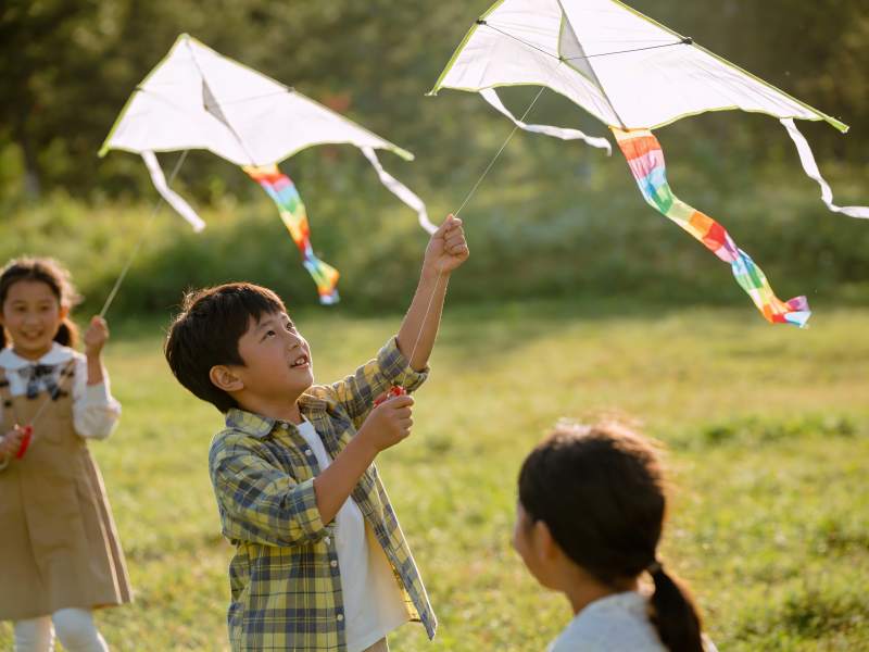 三名儿童户外放风筝图片
