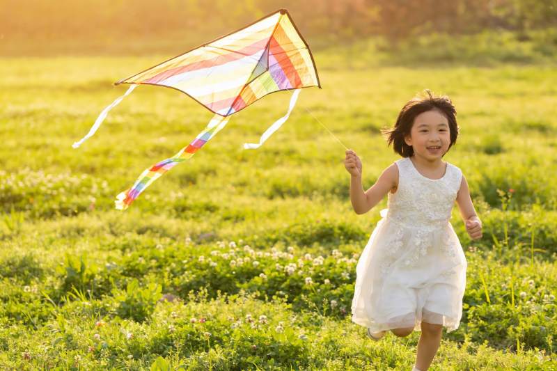 小女孩草地上放风筝图片