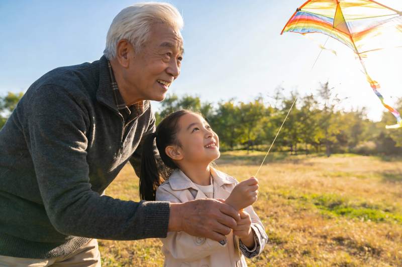 爷爷陪孙女户外放风筝图片