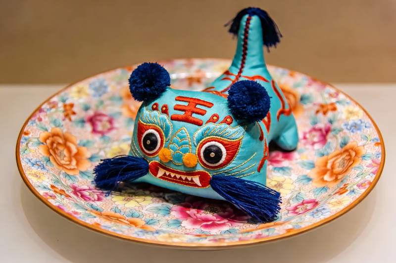 传统布老虎摆件置于花盘之上图片