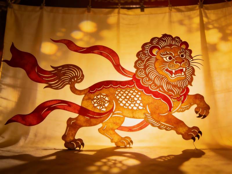 光影中的传统狮子剪纸艺术图片