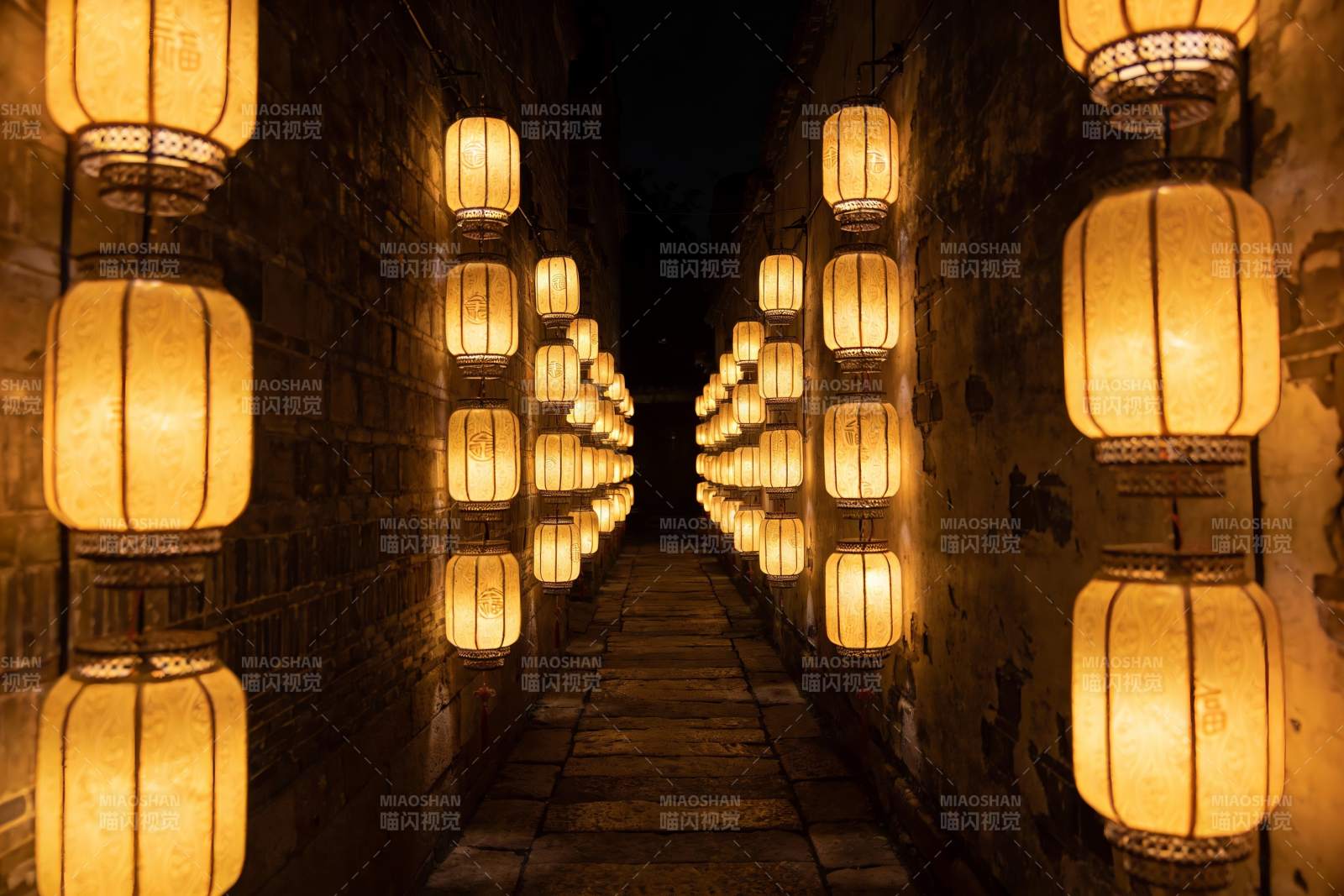 古巷夜灯映照石板路图片