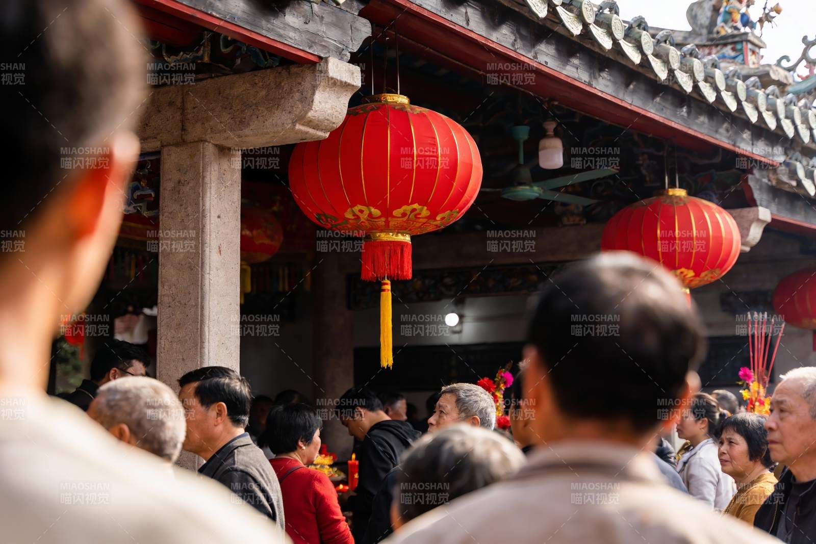 古建筑前人群聚集挂红灯笼图片