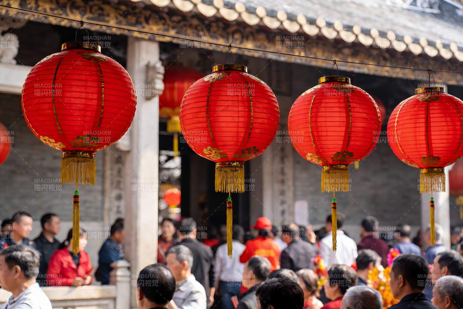 古建筑前挂红灯笼人群聚集图片