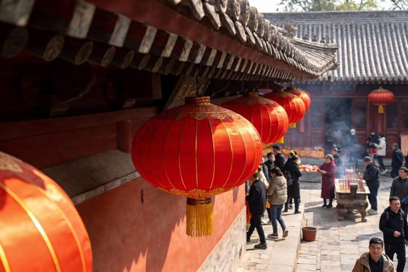 古建筑前挂红灯笼祈福人群图片