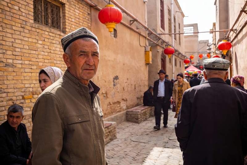 古巷中身着民族服饰的老人图片