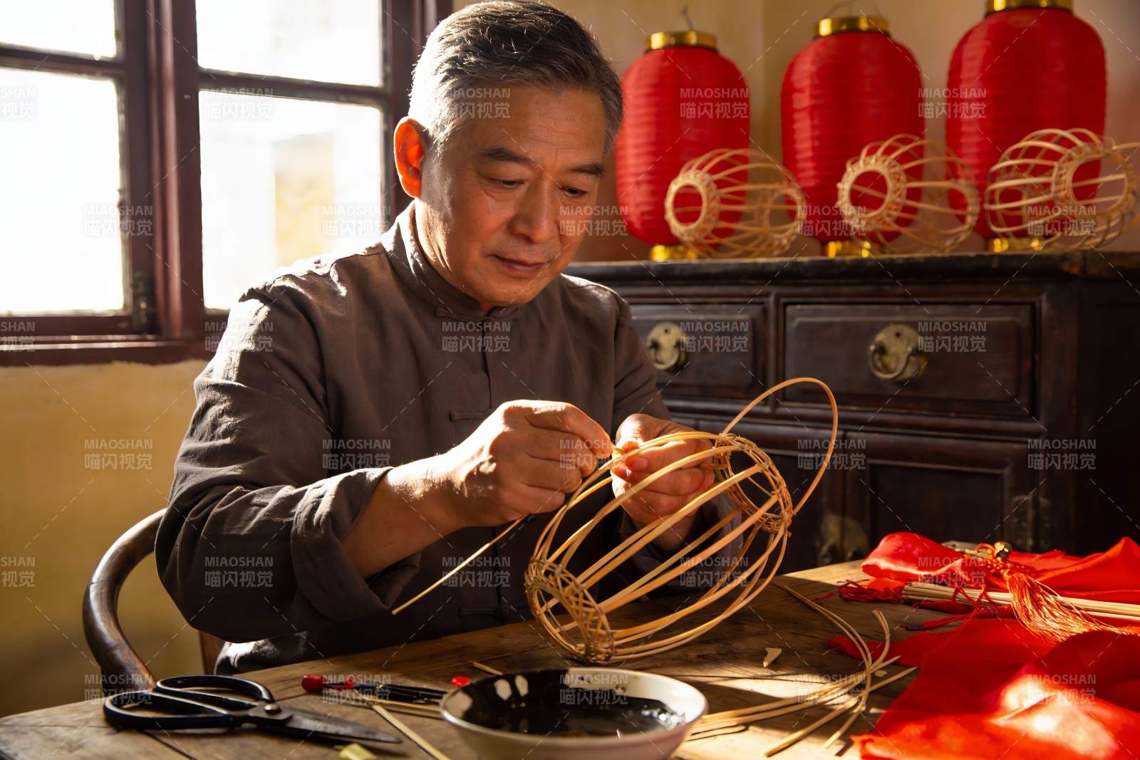 老人制作传统灯笼的手工艺场景图片
