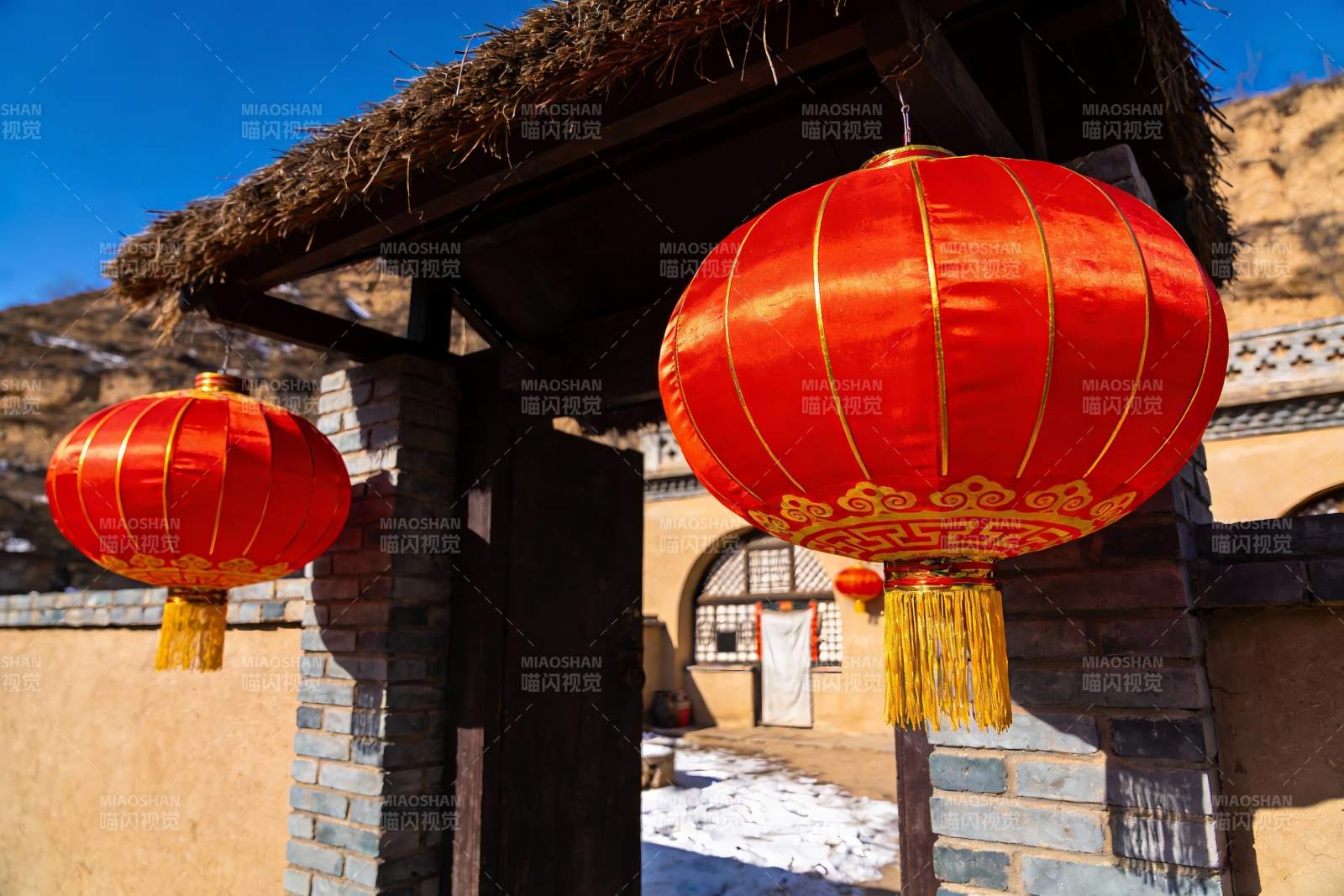 红灯笼映衬古朴村落入口图片