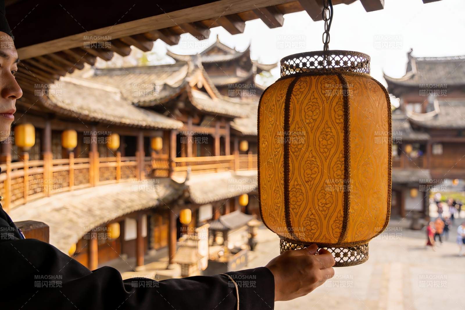 古建筑前手持灯笼的男子图片