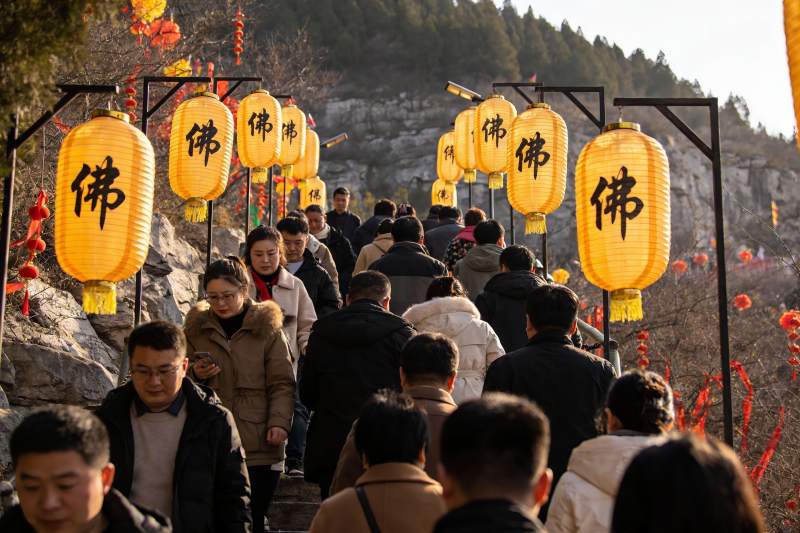 人群攀登挂满灯笼的山道图片