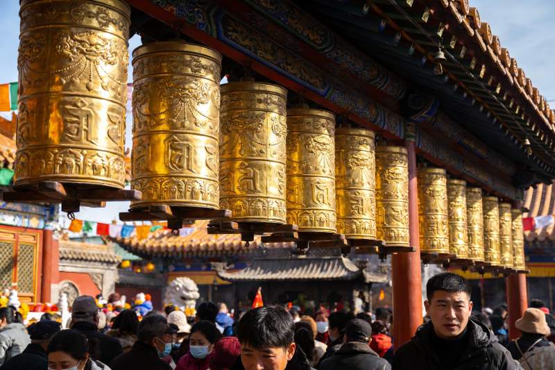 寺庙金色转经筒与人群图片