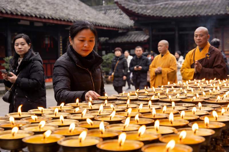 寺庙中众人点燃蜡烛祈福图片