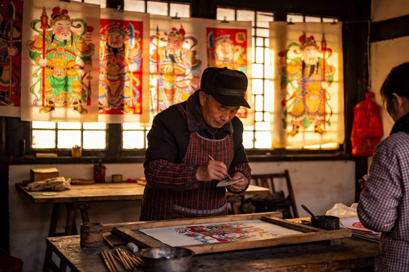 老人专注绘制传统年画图片