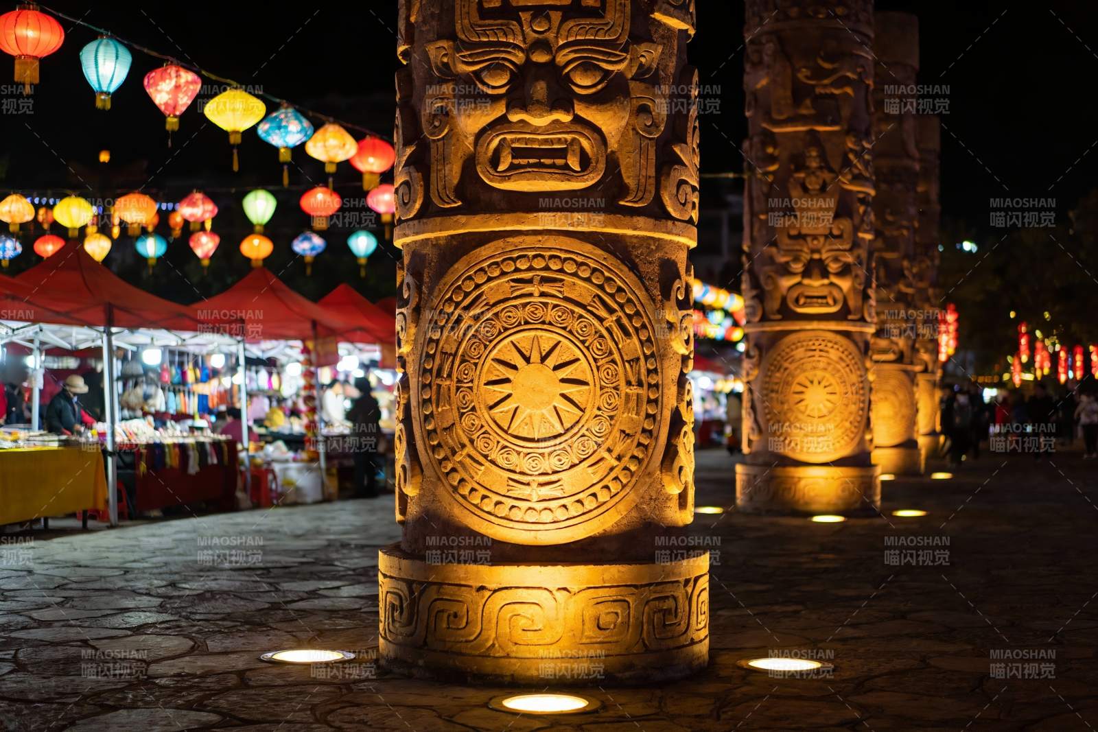 夜市古柱彩灯映衬热闹场景图片